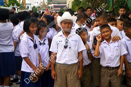 Thai school students wearing uniforms visit The Grand Palace in Bangkok, Thailand.