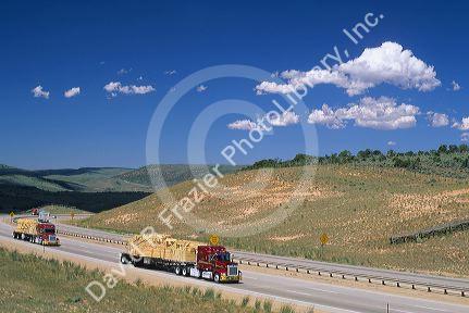 Trucks hauling an oversized load of lumber on Interstate 80 in Wyoming.