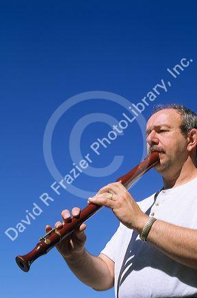 A man play a tenor recorder.