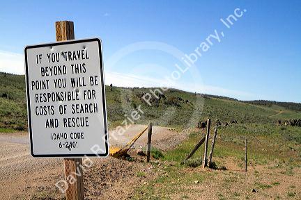 Road sign warning of search and rescue costs for traveling on unimproved road in Owyhee County, Idaho, USA.