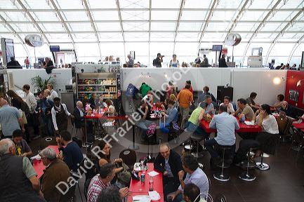 Travelers in a waiting room at Charles de Gaulle Airport, Paris, France.