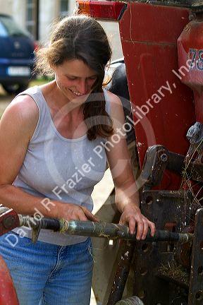 French woman working on farm equipment near Angouleme in southwestern France. MR