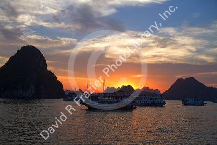 Tour boats at sunset in Ha Long Bay, Vietnam.