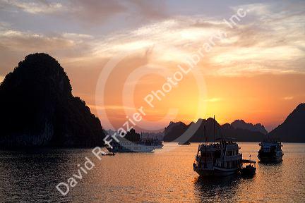 Tour boats at sunset in Ha Long Bay, Vietnam.