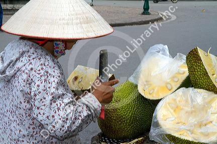 Vietnamese street vendor selling durian fruit in Hanoi, Vietnam.