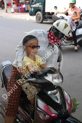 Mother and child riding a motor scooter together in Nha Trang, Vietnam.