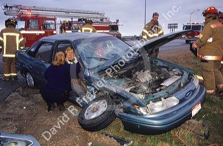 Firefighters assist in the aftermath of an automobile accident.
