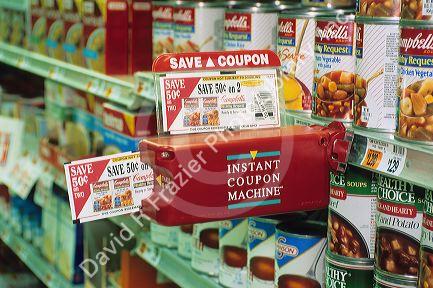 A supermarket coupon dispensing device sticks out in the aisle.