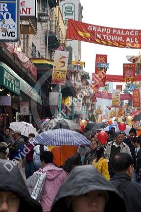 People walking with umbrellas in Chinatown, San Francisco, California.