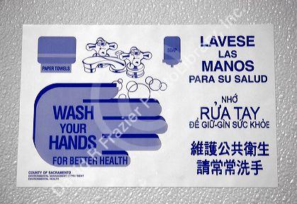Wash your hands sign in a bathroom showing differnt languages. Spanish, Vietnamese, Korean, English