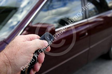 Person using a remote system to lock and unlock car doors.