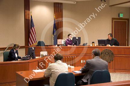 Court room scene with  in Boise, Idaho.  Criminal defendant  and lawyer sit with backs to camera.