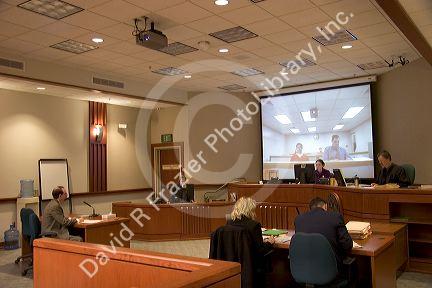 Video arraignment in criminal court in Boise, Idaho.  Defendants appear on video screen from secure jail facility while judge in courtroom conducts arraignment and sets bond.