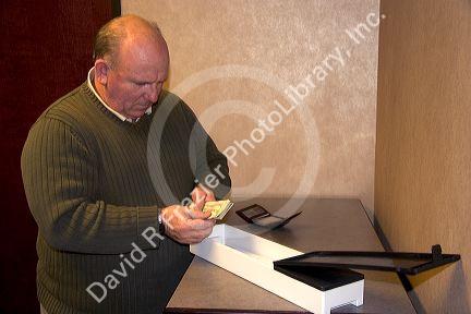 Man putting cash into a safe deposit box.