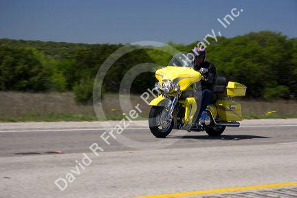 Morotcyclist on yellow road bike cruises Interstate 10 in West Texas.
