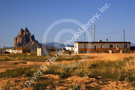 Trailer home in front of Ship Rock in New Mexico Navajo Indian reservation.