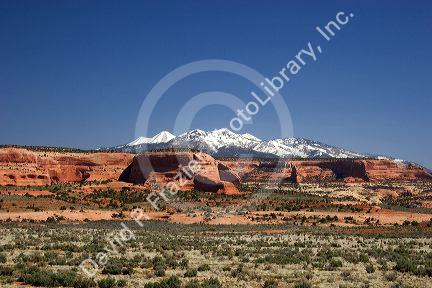 A view of snowy La Sal mountains and sandstone along US highway 191 south of Moab, Utah.