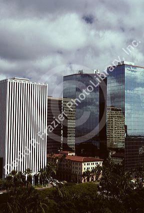 Steel and glass skyscrapers rise above smaller older buildings in Honolulu, Hawaii.