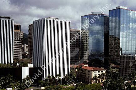 Steel and glass skyscrapers rise above smaller older buildings in Honolulu, Hawaii.