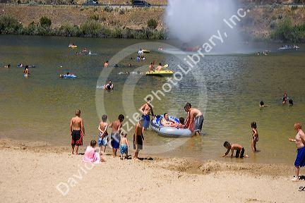 Adults and children play on the beach and in the water at Sandy Point near Boise, Idaho.