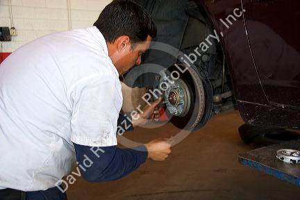 Mechanic checking brake rotor on automobile.