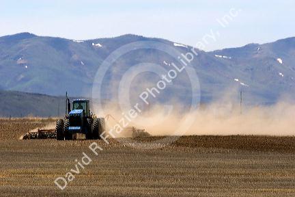 Farm tractor disking field in camas County, Idaho.