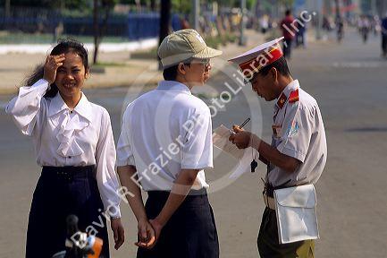 A Saigon police officer writes a ticket, Vietnam.
