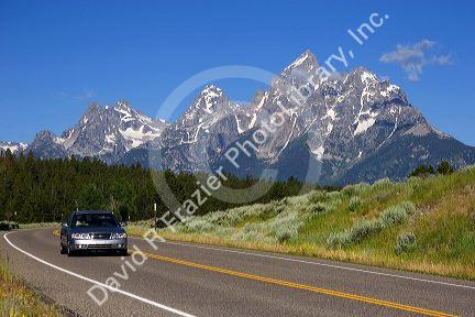 Automobile driving on highway near the Teton Mountains, Wyoming.