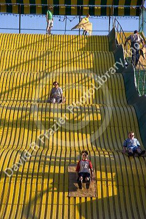 Children ride down a giant yellow slide at the Iowa state fair in Des Moines.