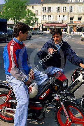 Teens ride motorbikes in France.