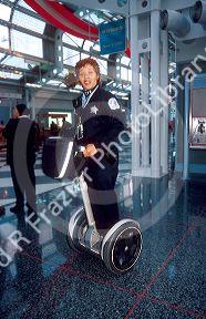 Female Chicago police officer riding a Segue gyro scooter at O'hare airport.