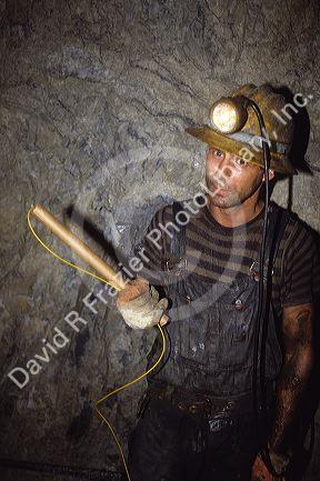 Miner holding a stick of dynamite in a silver mine at Wallace, Idaho.