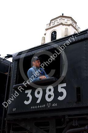 Railroad engineer at the window of a vintage Challenger steam engine visiting Boise, Idaho.