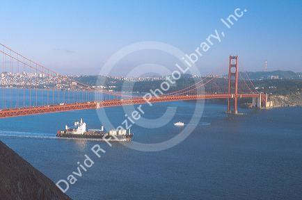 Cargo ship passing under the Golden Gate Bridge in San Francisco, California.