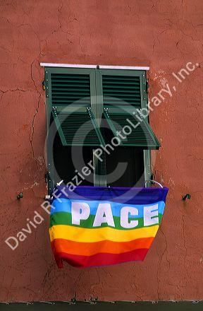 A peace flag hangs from the window of an apartment in Italy.