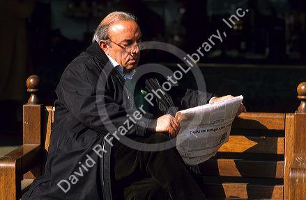 An Italian man reading a newspaper in Italy.