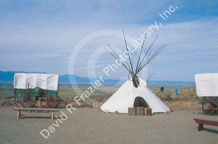 A covered wagon and teepee stand outside of the Oregon Trail Museum in Baker, Oregon.