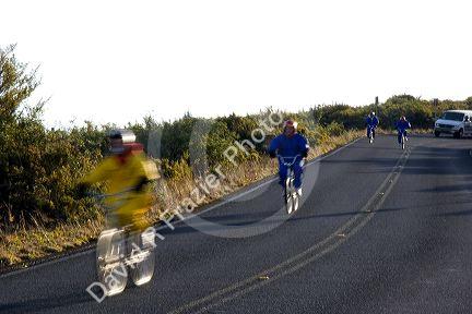 Tourists ride bicycles down Mount Haleakala on the island of Maui, Hawaii.
