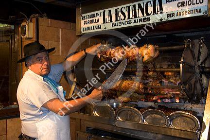 A rotisserie chef with cooked chicken in Buenos Aires, Argentina at la Estancia Restaurant.
