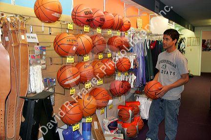 Teen shops for a basketball at a sporting goods store in Boise, Idaho.