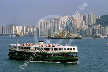 Star Ferry and skyscraper buildings at Hong Kong Harbor.