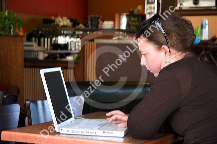 A woman using a laptop computer in a coffee shop, Boise, Idaho. MR