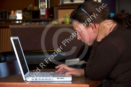 A woman using a laptop computer in a coffee shop, Boise, Idaho. MR