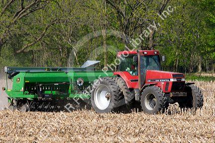 Tractor using the practice of minimum tillage for planting soy beans over last years corn crop near Clarksville, Michigan.