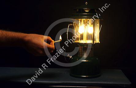 A match being used to light a gasoline lantern.