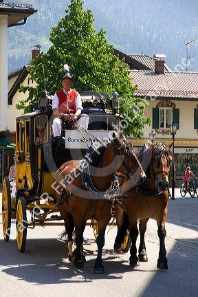 Street scene with a horse drawn stage coach in the alpine village of Garmisch, Germany.