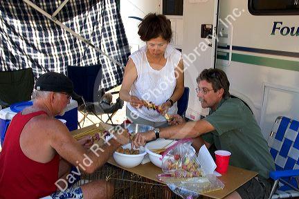 Campers preparing shish kabob meal.