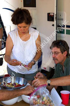 Campers preparing shish kabob meal.