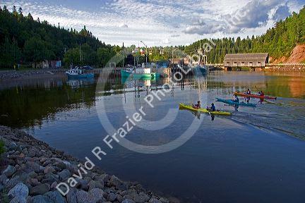 People sea kayaking at high tide in the Bay of Fundy at St. Martins, New Brunswick, Canada.
