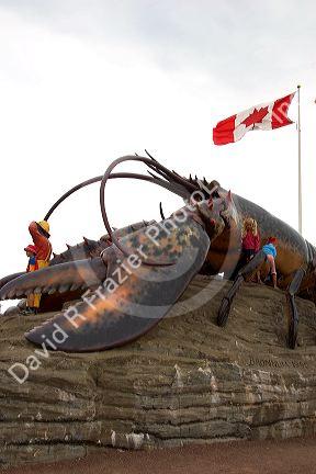 Children play on a large lobster statue at Shediac, home of the world's largest lobster, New Brunswick, Canada.